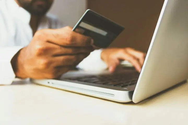 Cliente pagando con tarjeta una compra en línea desde su laptop